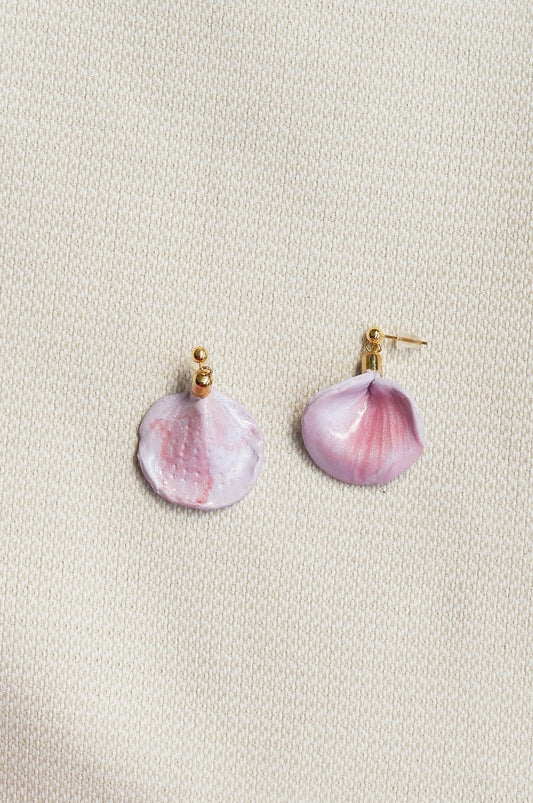 Pink petal-shaped earrings on a light beige background