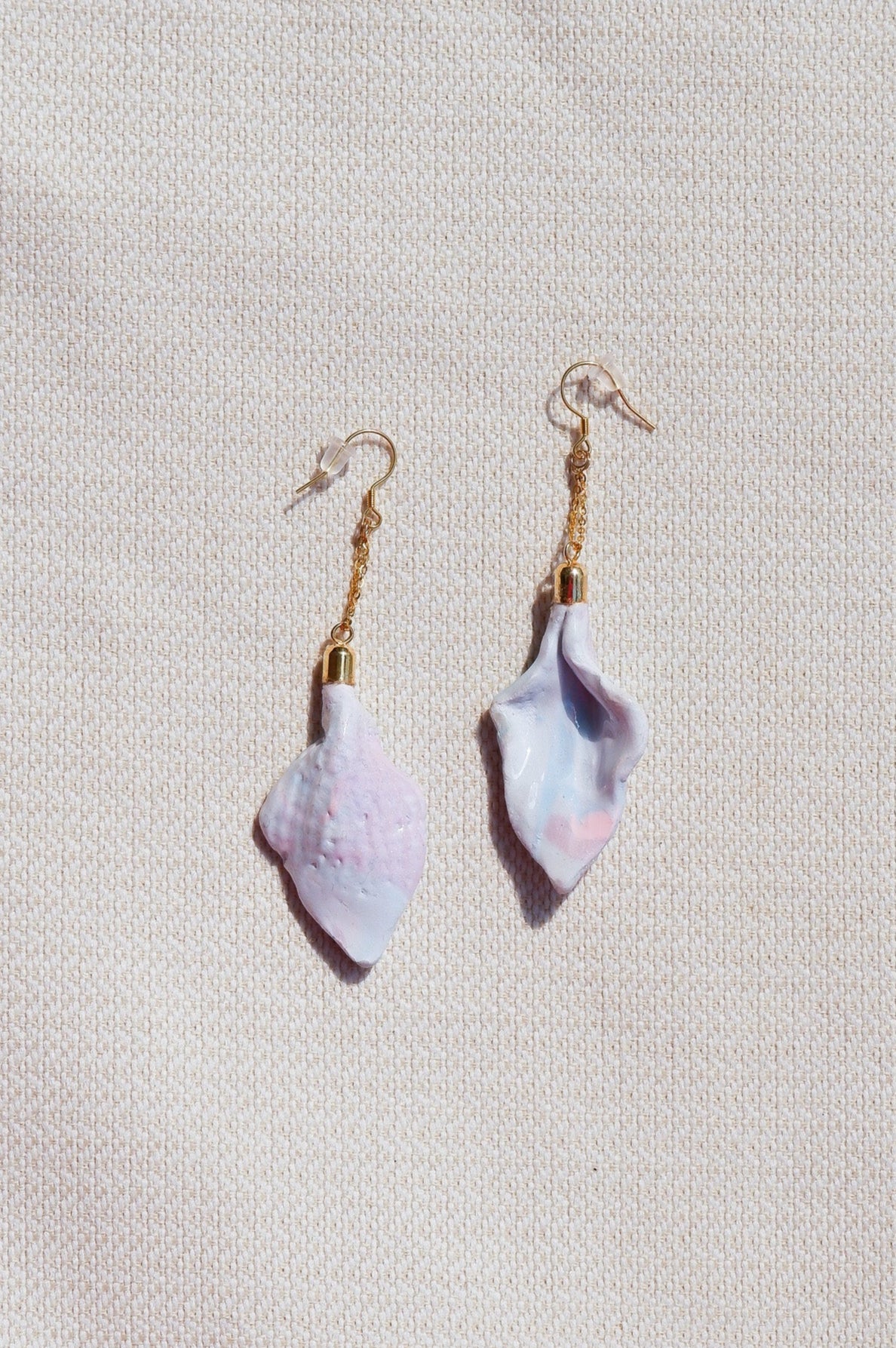 Pair of shell-shaped earrings on a light gray background