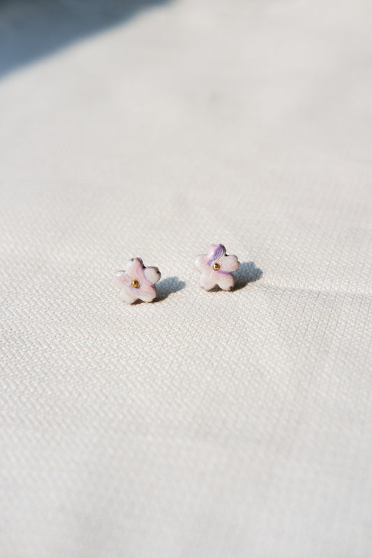 Flower-shaped earrings on a textured white surface